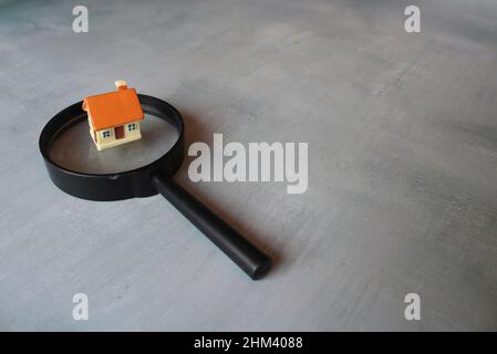 Recherche de maison, concept d'inspection de maison. Loupe et maison de jouets. Copier l'espace pour le texte Banque D'Images