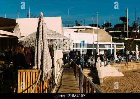 Parede, Cascais, Portugal - 5 février 2022 : les gens profitent d'un après-midi d'été chaud à la plage de Parede, Portugal Banque D'Images