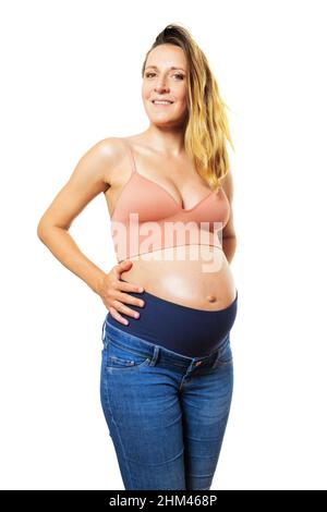 Une femme enceinte heureuse tient le gros ventre sur le blanc Banque D'Images
