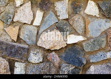 Gros plan d'un fragment d'un vieux mur de pierre naturelle. Banque D'Images