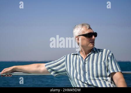 Un homme en lunettes de soleil se repose sur un yacht dans la mer Rouge.Gros plan.Hurghada, Égypte - octobre 2021 Banque D'Images