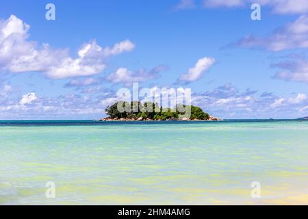 Île tropicale inhabitée, Chauve souris, qui dépasse de l'océan Indien, avec de l'eau turquoise et un ciel bleu cristal, Praslin, Seychelles. Banque D'Images