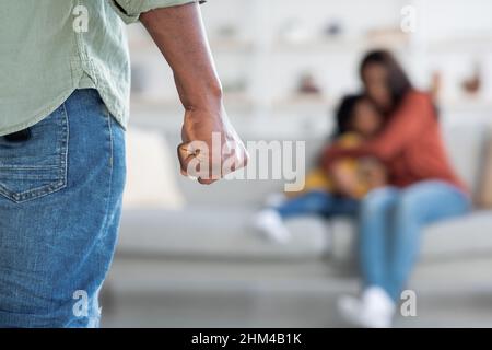 Violence domestique.Homme afro-américain menaçant femme et fille avec son poing Banque D'Images