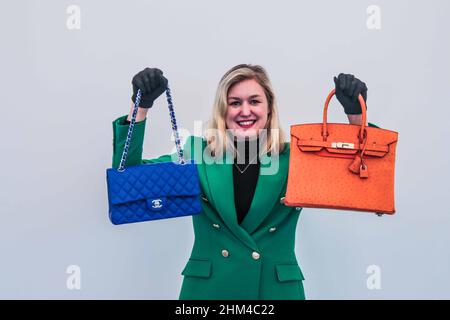 Londres 08 Fév 2022 Model Holding (L) a Royal Blue Quilted lambskin Classic double rabat Chanel, 2019, estimation £ 3 000 – 5 000 (R)Orange H Ostrich Birking 30 Hermès, 2002, estimation £8 000 – 12 000.Paul Quezada-Neiman/Alay Live News Banque D'Images