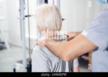 Spécialiste médical offrant un massage des épaules à une femme âgée Banque D'Images