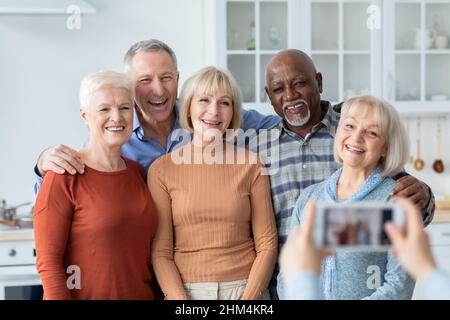 Personne méconnaissable prenant la photo d'un groupe multiracial de personnes âgées Banque D'Images