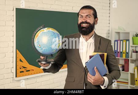 Portrait d'un enseignant d'école dans la classe académique avec globe, géographie Banque D'Images