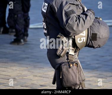 Braunschweig, Allemagne, 8 janvier 2022 : pistolet dans l'étui d'un policier noir en uniforme portant un casque de protection devant sa poitrine sur le Banque D'Images