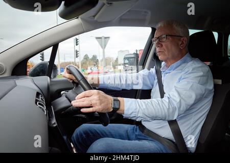 Photographie d'un homme plus âgé conduisant une voiture à droite, Royaume-Uni. Banque D'Images