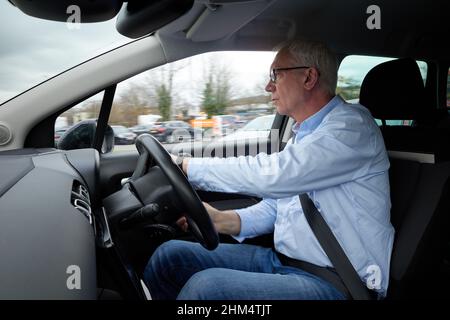 Photographie d'un homme plus âgé conduisant une voiture à droite, Royaume-Uni. Banque D'Images
