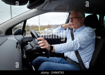 Photographie d'un homme plus âgé conduisant une voiture à droite, Royaume-Uni. Banque D'Images