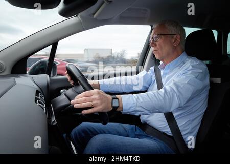 Photographie d'un homme plus âgé conduisant une voiture à droite, Royaume-Uni. Banque D'Images