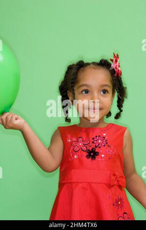 Gros plan d'Une fille tenant Un ballon et regardant loin, crédit:Photohot Creative / Stuart Cox / Avalon Banque D'Images