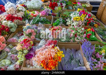 Fleurs artificielles en plastique dans des boîtes au marché chinois Banque D'Images