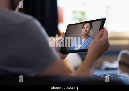 Homme ayant une consultation de médecin en ligne sur la tablette numérique Banque D'Images
