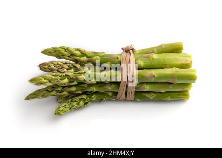 Bouquet d'asperges vertes fraîches isolées sur fond blanc. Vue de côté, gros plan. Récolte, santé, nourriture végétalienne, concept, minimalisme. Banque D'Images