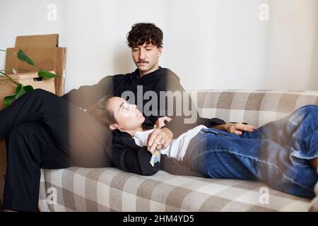 Young couple sitting on sofa Banque D'Images