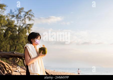 Femme sur la plage portant un masque Banque D'Images