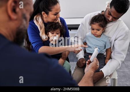 Médecin de sexe masculin examinant la famille avec des enfants Banque D'Images