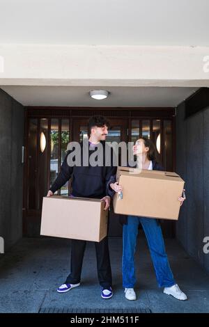Couple souriant transportant des boîtes en carton Banque D'Images