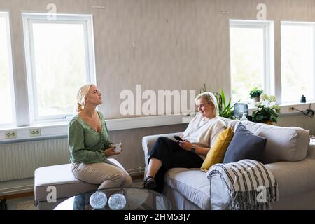 Des amies qui parlent dans la salle de séjour Banque D'Images