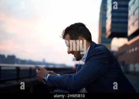 homme d'affaires à l'aube dans la ville dans un appel sur son portable Banque D'Images