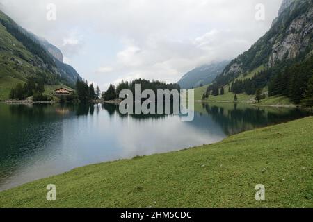 berggasthaus seealpsee suisse, grand lac en vue totale, avec île et hôtel restaurant, ciel nuageux jour d'été, atmosphère mystique Banque D'Images