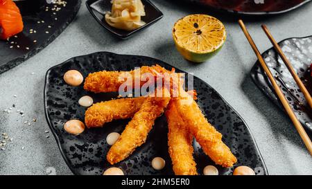 Gros plan de délicieuses crevettes de torpille panées sur une assiette sur la table dans un restaurant Banque D'Images