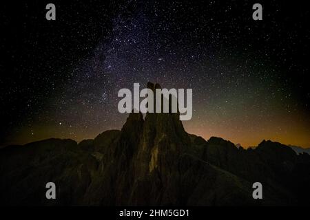 Voie lactée et étoiles au-dessus de la Torri di Vajolet du groupe Rosengarten, vu de l'ouest au-dessus de la cabane de montagne Rifugio Re Alberto I la nuit. Banque D'Images