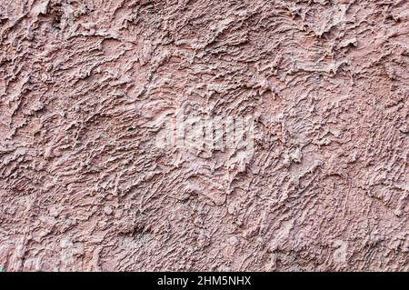 Fond de motif mural en plâtré rose en béton. Tissu rouge écarlate sur le mur pour un fond de grunge. Banque D'Images