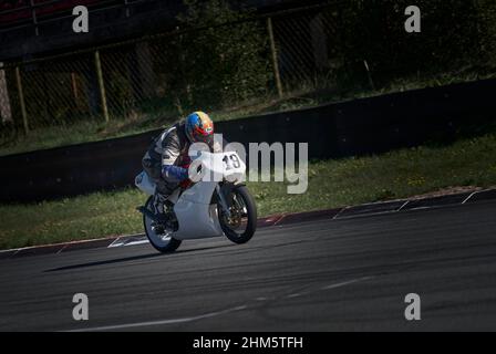 11-05-2021 Riga, Lettonie beau cavalier homme avec la barbe et la moustache en cuir noir veste de moto et lunettes de soleil assis sur le style classique café voiture de course Banque D'Images