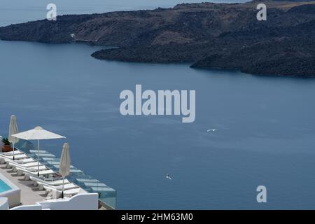 Santorini, Grèce - 7 mai 2021 : Une piscine avec chaises longues dans un hôtel de luxe donnant sur la mer égée à Santorini, Grèce Banque D'Images