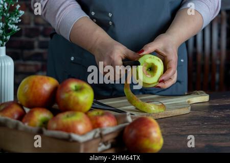 Les femmes préparant une tarte aux pommes ou une grande tarte sur fond de table en bois. Banque D'Images