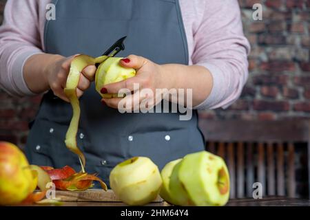 Les femmes préparant une tarte aux pommes ou une grande tarte sur fond de table en bois. Banque D'Images