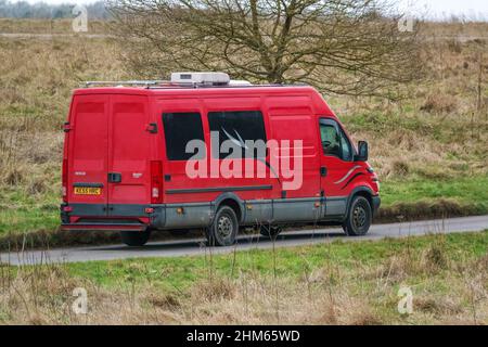 Une longue base de roues Iveco Daily 355 2,3 HPI minibus rouge conduite le long d'une route de campagne Banque D'Images