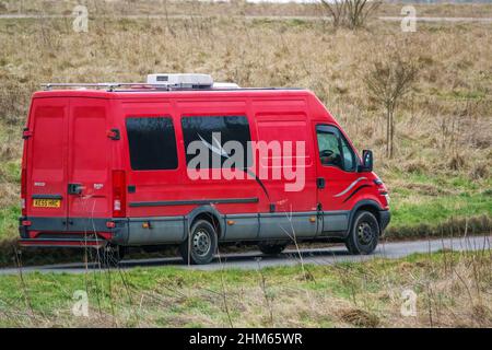 Une longue base de roues Iveco Daily 355 2,3 HPI minibus rouge conduite le long d'une route de campagne Banque D'Images
