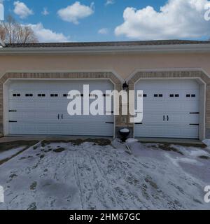 Carré blanc pouffy nuages attachés trois-voiture garage extérieur de la maison avec des briques Banque D'Images