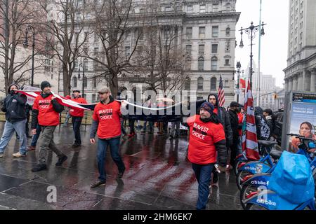 New York, NY - le 7 février 2022 : des dizaines de manifestants portant des drapeaux américains et canadiens affronte la pluie brave sur le pont de Brooklyn et se rassemblent à l'hôtel de ville contre le mandat de vaccination Banque D'Images