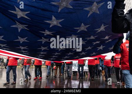 New York, NY - le 7 février 2022 : des dizaines de manifestants portant des drapeaux américains et canadiens affronte la pluie brave sur le pont de Brooklyn et se rassemblent à l'hôtel de ville contre le mandat de vaccination Banque D'Images