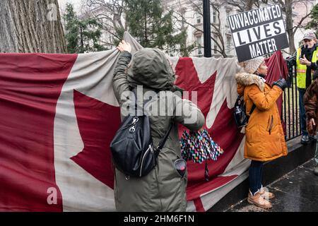 New York, NY - le 7 février 2022 : des dizaines de manifestants portant des drapeaux américains et canadiens affronte la pluie brave sur le pont de Brooklyn et se rassemblent à l'hôtel de ville contre le mandat de vaccination Banque D'Images