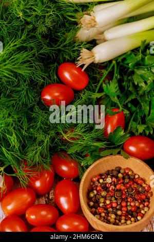 Tomates cerises rouges, oignons verts et aneth aux épices. Banque D'Images