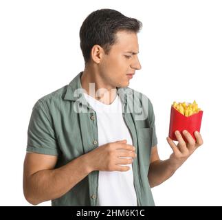 Jeune homme stressé avec frites sur fond blanc Banque D'Images