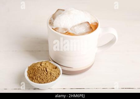 Tasse de délicieux latte glacés hojicha et de poudre sur fond de bois clair Banque D'Images