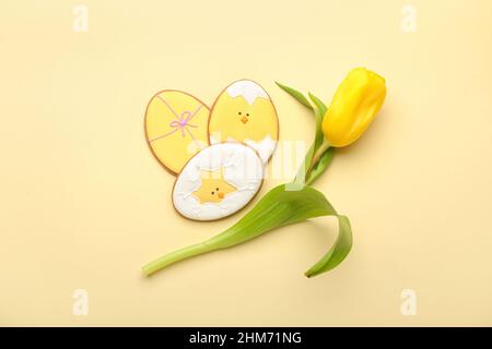 Composition avec biscuits de Pâques créatifs et fleurs sur fond jaune Banque D'Images