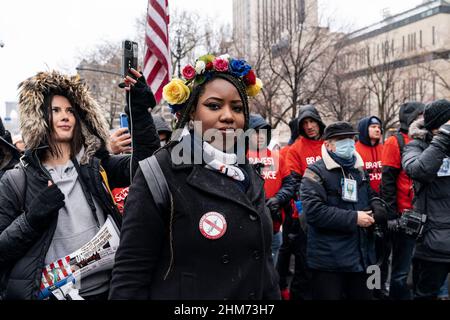 Des dizaines de manifestants portant des drapeaux américains et canadiens font braver la pluie sur le pont de Brooklyn march et se rassemblent à l'hôtel de ville contre le mandat de vaccination. Les employés de la ville ont été informés que tous les sujets non entièrement vaccinés seront mis fin en février 11. Les manifestants ont été rejoints par des membres du New York Freedom Rally. Beaucoup portaient des drapeaux américains ainsi que des drapeaux canadiens pour appuyer les camionneurs qui ont protesté de la même façon dans la capitale du Canada, Ottawa. Une femme porte une épingle avec la déclaration fièrement non vacciné. (Photo de Lev Radin/Pacific Press) Banque D'Images