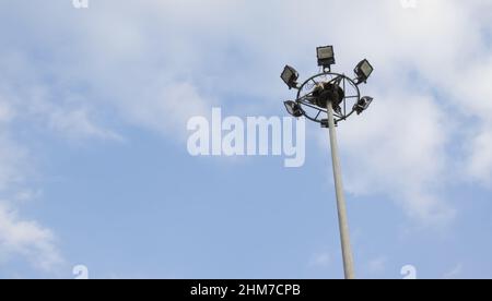 Mât lumineux avec ciel bleu et nuage en ville. Tour de spot. Pour la sécurité des personnes de nuit. Banque D'Images