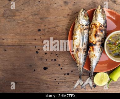Poisson grillé dans une assiette et sauce épicée aux fruits de mer Banque D'Images