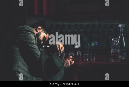 Homme ivre tenant le verre. Client de pub de bière dormant et allongé avec sa tête sur la table. Concept d'abus d'alcool et de toxicomanie. Banque D'Images