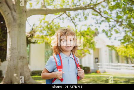 Enfant avec sacs à dos debout dans le parc près de l'école. Élèves avec des livres et des sacs à dos à l'extérieur. Concept d'éducation des enfants. Banque D'Images