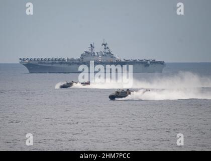 MER DES PHILIPPINES (fév 7, 2022) les navires de l'Amérique et des groupes de prêts amphibies d'Essex, et le groupe de grève des transporteurs Abraham Lincoln, naviguent en formation avec la Force d'autodéfense maritime du Japon pendant l'exercice Noble Fusion. Navire d'assaut amphibie de classe américaine USS America (LHA 6), arrière et embarcation, coussin d'air attaché à l'unité d'embarcation d'assaut (ACU) 5 naviguent en formation à l'appui de Noble Fusion, le 7 février 2022. Noble Fusion souligne que les forces expéditionnaires navales déployées par la Marine et le corps des Marines peuvent rapidement regrouper les équipes de l'unité expéditionnaire maritime/du groupe de préparation amphibie à Banque D'Images